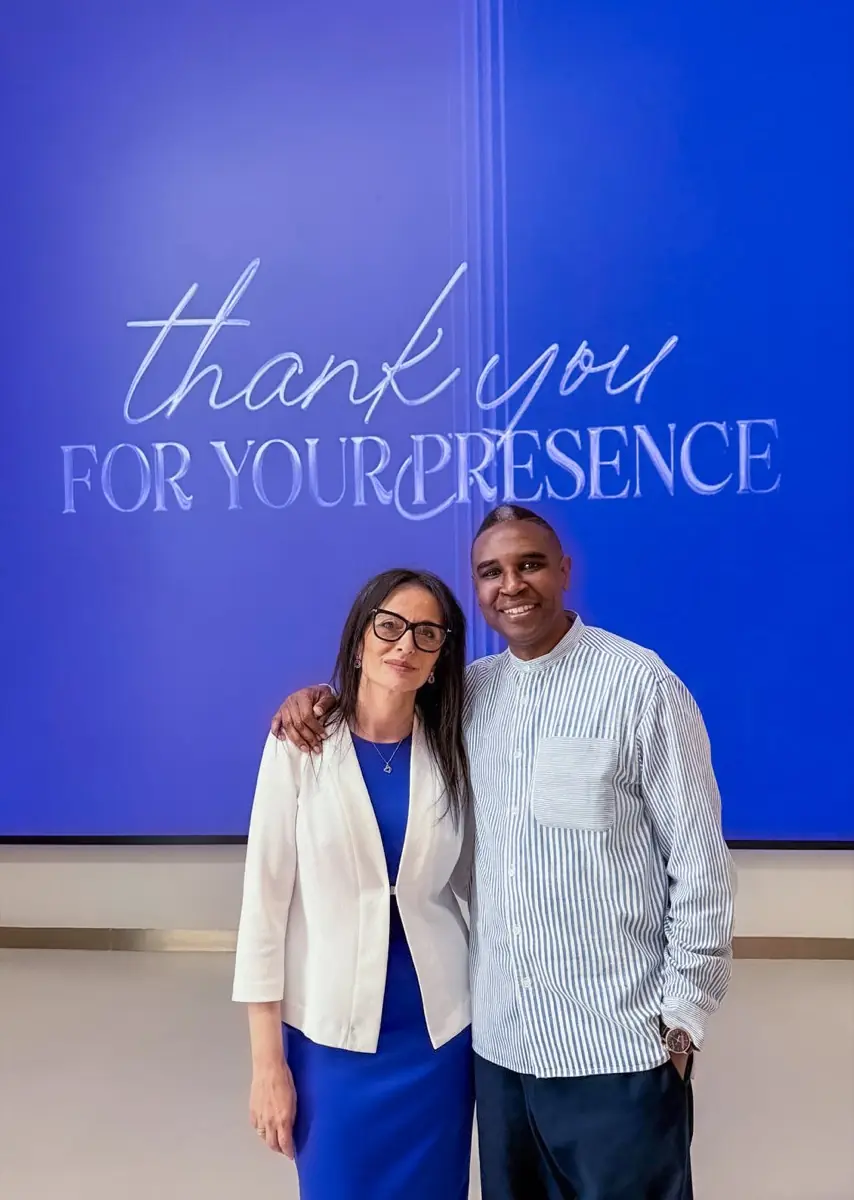 Bouchra Danwra with Bobby Jones in front of a screen reading “thank you for your presence”